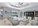 Spacious living room with neutral tones, tile flooring, and sliding glass doors to the screened-in lanai and pool at 8615 59Th E St, Parrish, FL 34219