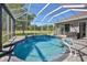 Sparkling pool surrounded by pavers, enclosed by a screen, and view of the yard, offering a private outdoor oasis at 8615 59Th E St, Parrish, FL 34219