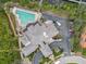 Aerial view of a clubhouse, a pool surrounded by lush landscaping, a parking area, and scenic surroundings at 9818 Portside Ter, Bradenton, FL 34212