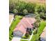 Aerial shot of a single-story home with a red tile roof, lush landscaping, and a screened-in lanai at 9818 Portside Ter, Bradenton, FL 34212