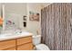 Bathroom with wood cabinets, ample counter space, and a shower with modern curtain at 9818 Portside Ter, Bradenton, FL 34212
