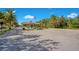 Gated community entrance with a manicured landscape, tile roofed guard house, and an American flag flying proudly at 9818 Portside Ter, Bradenton, FL 34212