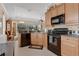 Bright kitchen boasting stainless appliances, wood cabinets, and an open layout to the dining area at 9818 Portside Ter, Bradenton, FL 34212