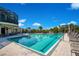 Community pool with clear blue water, surrounded by lounge chairs and lush tropical landscaping, creating a resort-like atmosphere at 9818 Portside Ter, Bradenton, FL 34212