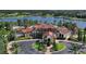 Stunning aerial view of a luxurious community clubhouse near a lake with lush landscaping and elegant architecture at 16436 Daysailor Trl, Lakewood Ranch, FL 34202