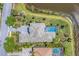 Aerial view of home with a luxurious pool, manicured landscaping and tranquil lakeside setting at 16436 Daysailor Trl, Lakewood Ranch, FL 34202