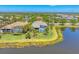 Waterfront house aerial view with lush landscaping and private screened in pool on a sunny day at 16436 Daysailor Trl, Lakewood Ranch, FL 34202