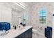 Nicely wallpapered bathroom featuring a sink, toilet, and shower/tub combination, providing a complete and stylish space at 16436 Daysailor Trl, Lakewood Ranch, FL 34202