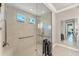 Bright shower with a glass wall, marble tile, grab bars, and a view out the window at 16436 Daysailor Trl, Lakewood Ranch, FL 34202
