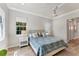 This bedroom features 3 windows, hardwood flooring, a ceiling fan, and a decorative plant at 16436 Daysailor Trl, Lakewood Ranch, FL 34202