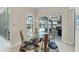 Bright dining area featuring a modern chandelier, glass table, and sliding glass doors to the outdoor pool area at 16436 Daysailor Trl, Lakewood Ranch, FL 34202