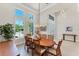 Inviting dining area with a large oval table, high windows, and a view of the home's entrance at 16436 Daysailor Trl, Lakewood Ranch, FL 34202