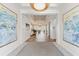 Elegant entryway featuring contemporary art and a modern chandelier, leading to a bright, open dining area at 16436 Daysailor Trl, Lakewood Ranch, FL 34202