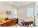 A home office featuring a wooden desk, a leather chair, and natural light at 16436 Daysailor Trl, Lakewood Ranch, FL 34202