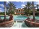 Beautiful swimming pool featuring fountains, red umbrellas, statues and a grand building in the background at 16436 Daysailor Trl, Lakewood Ranch, FL 34202