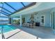 Inviting pool, outdoor kitchen and dining area under a screened lanai with relaxing lakeside views at 16436 Daysailor Trl, Lakewood Ranch, FL 34202