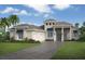 Stunning single-story home featuring a tile roof, a manicured lawn, an arched entryway, and a three-car garage at 1103 Blue Shell Loop, Sarasota, FL 34240