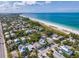 Aerial view showing neighborhood and beach access with white sand and light blue ocean water at 113 Palm Ave, Anna Maria, FL 34216