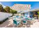 Backyard patio featuring an umbrella-covered dining table and access to the pool and spa at 113 Palm Ave, Anna Maria, FL 34216