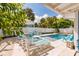 Backyard featuring a pool, lounge chairs, and outdoor dining, ideal for relaxation and entertaining at 113 Palm Ave, Anna Maria, FL 34216