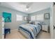 This cute bedroom features a ceiling fan, light blue walls and neutral tile floors at 113 Palm Ave, Anna Maria, FL 34216