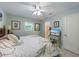 Comfortable bedroom with a ceiling fan, wall decor and an en suite bath at 113 Palm Ave, Anna Maria, FL 34216