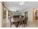 Open-concept dining and living room with a chandelier, ceiling fan, tile floors, and beige walls at 113 Palm Ave, Anna Maria, FL 34216