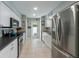 Modern kitchen featuring white cabinets, stainless steel appliances, and easy outdoor access at 113 Palm Ave, Anna Maria, FL 34216