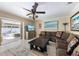 Living room features a large sectional, decor, a ceiling fan, and sliding doors to the pool area at 113 Palm Ave, Anna Maria, FL 34216
