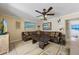 Living room features a brown sectional, colorful decor, a ceiling fan, and tile floors at 113 Palm Ave, Anna Maria, FL 34216