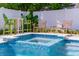 Outdoor spa with blue mosaic tiles surrounded by outdoor seating and lush landscaping at 113 Palm Ave, Anna Maria, FL 34216