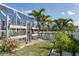 Lush backyard with white fence, pool, palm trees, and greenery at 11542 Summit Rock Ct, Parrish, FL 34219