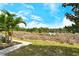 Lush backyard with paved path and view of a peaceful pond, offering a tranquil outdoor space at 11723 Cullen Park Ter, Bradenton, FL 34211