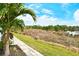 Backyard path with view of serene pond surrounded by lush greenery, creating a peaceful retreat at 11723 Cullen Park Ter, Bradenton, FL 34211