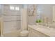 Bright bathroom featuring white tile, marble counters, updated fixtures, and a decorative accent wall at 11723 Cullen Park Ter, Bradenton, FL 34211