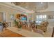 Dining area showcasing stylish chairs, a wooden table, and a view into the bright living room at 11723 Cullen Park Ter, Bradenton, FL 34211