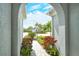 Arched entryway providing a glimpse of the landscaped yard, blue skies, and neighborhood beyond at 11723 Cullen Park Ter, Bradenton, FL 34211