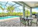 Open-air patio featuring a dining set, ceiling fan, brick pavers and views of the pool and lake at 11723 Cullen Park Ter, Bradenton, FL 34211