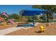 Community playground featuring climbing structures, covered picnic tables, and a small bumble bee spring rider at 11723 Cullen Park Ter, Bradenton, FL 34211