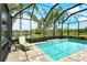 Relaxing screened-in pool area with mature tropical landscaping and views of the adjacent pond at 11723 Cullen Park Ter, Bradenton, FL 34211