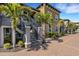 Beautiful exterior of a condo featuring a staircase entrance with tropical landscaping and a brick paved drive at 12405 Osorio Ct # 202, Sarasota, FL 34238