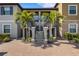 Beautiful condo exterior featuring a staircase entrance with tropical landscaping and brick paved parking at 12405 Osorio Ct # 202, Sarasota, FL 34238