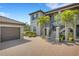 Charming condo exterior with brick paver driveway, two-car garage and well-maintained landscaping with palm trees at 12405 Osorio Ct # 202, Sarasota, FL 34238