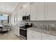 Modern kitchen featuring stainless steel appliances, granite countertops, and ample cabinet space at 12405 Osorio Ct # 202, Sarasota, FL 34238