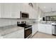 Well-equipped kitchen with stainless steel appliances, granite counters, and white cabinets at 12405 Osorio Ct # 202, Sarasota, FL 34238