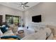 Bright living room featuring a ceiling fan, large TV, and sliding glass doors to a balcony at 12405 Osorio Ct # 202, Sarasota, FL 34238