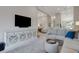An open living room showcases a decorative console under a TV and a gray couch with blue pillow at 12405 Osorio Ct # 202, Sarasota, FL 34238