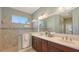 Bathroom featuring a double vanity, tiled shower, and a large mirror at 14404 Stirling Dr, Lakewood Ranch, FL 34202