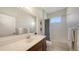 Bright bathroom with a spacious vanity, framed mirror, and a shower with a patterned curtain at 14404 Stirling Dr, Lakewood Ranch, FL 34202