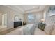 Bright bedroom features a tray ceiling, light wood floors, a large window, and neutral decor at 14404 Stirling Dr, Lakewood Ranch, FL 34202